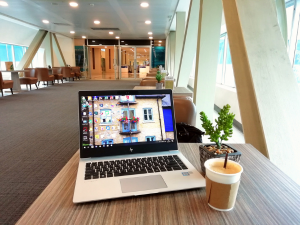 A modern office lounge with a laptop and coffee.