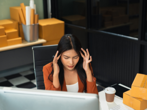 Frustrated small business owner facing ransomware attack losses at her office desk.