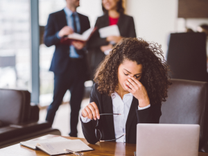 Frustrated office employee struggling with an unreported IT problem at her desk.