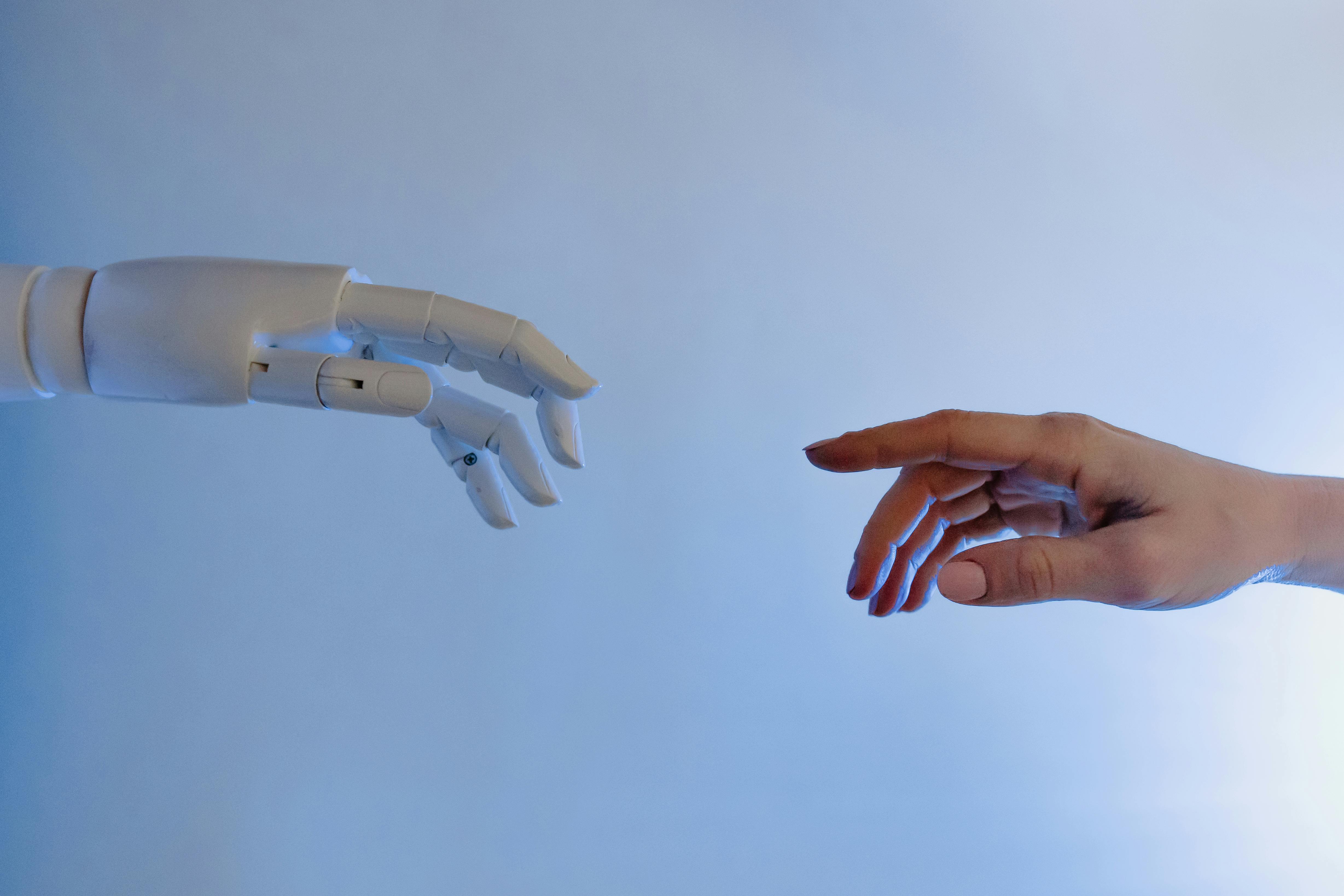 Human hand and robot hand reaching out to each other