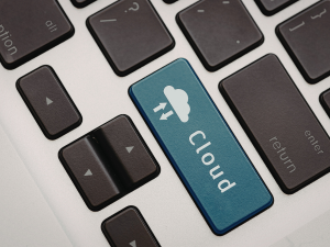 Close-up of a blue cloud computing key on a laptop keyboard representing cloud services for small business