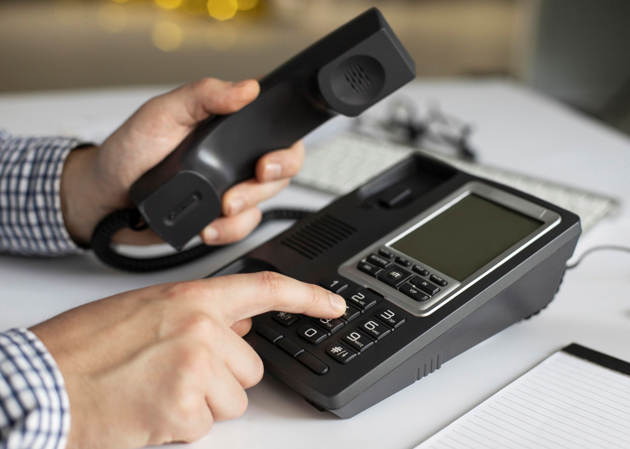 Close up of hands holding telephone and dialing.
