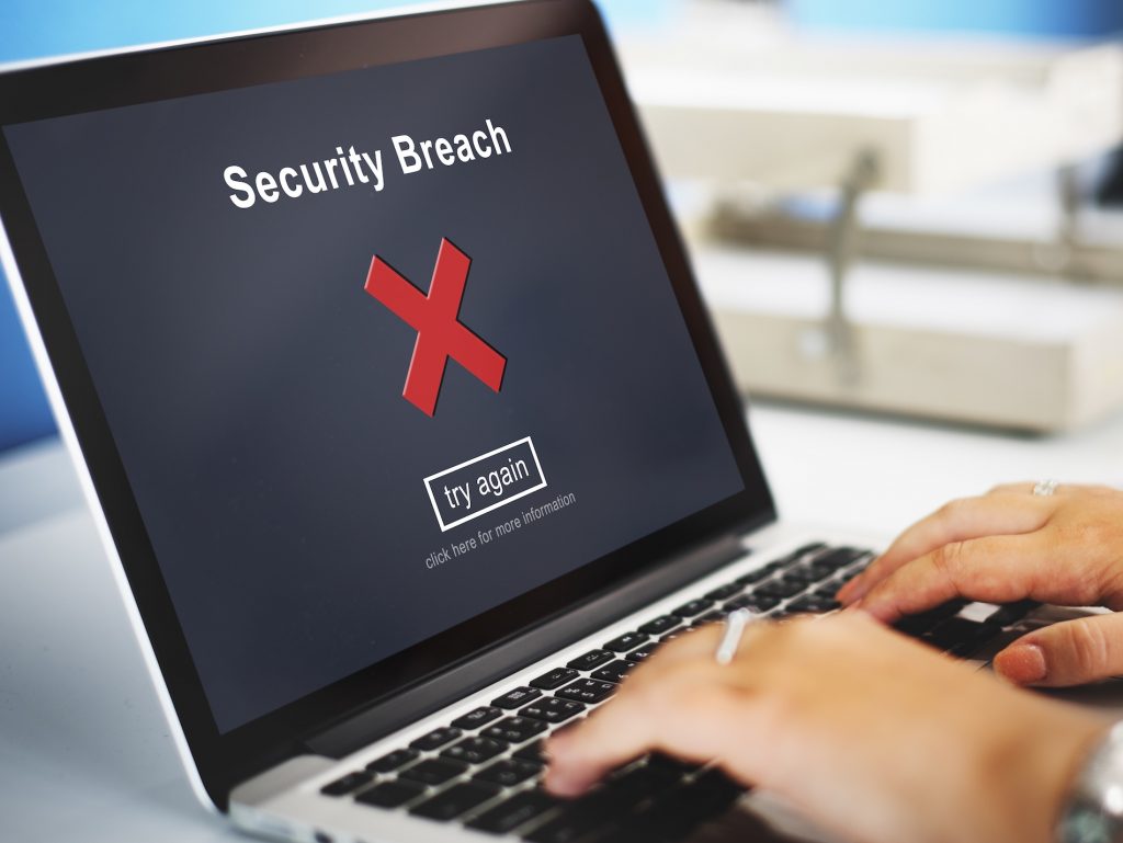 Laptop displaying a security breach warning caused by unsupported business software.