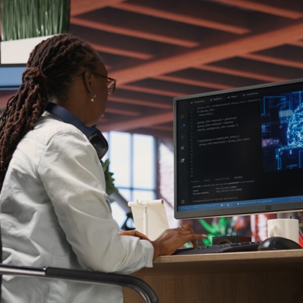Teleworking programmer using computer for artificial intelligence computing through self learning algorithms. Remote worker working with AI deep neural networks on desktop PC, camera B